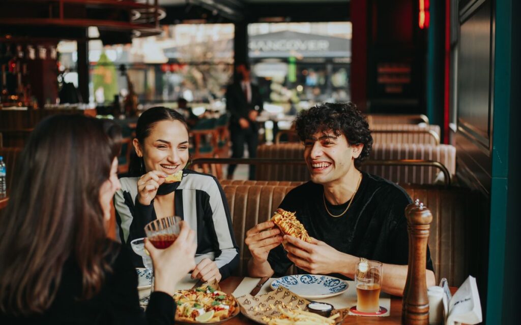 Grupo de amigos comendo e conversando em um restaurante