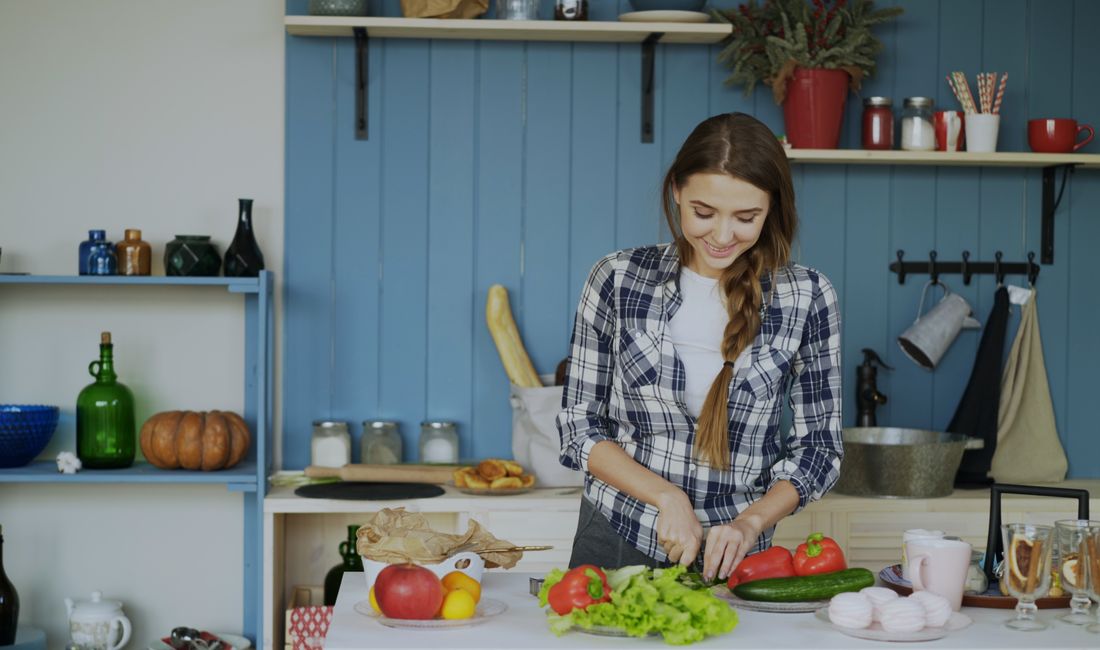 Mulher cortando legumes na cozinha