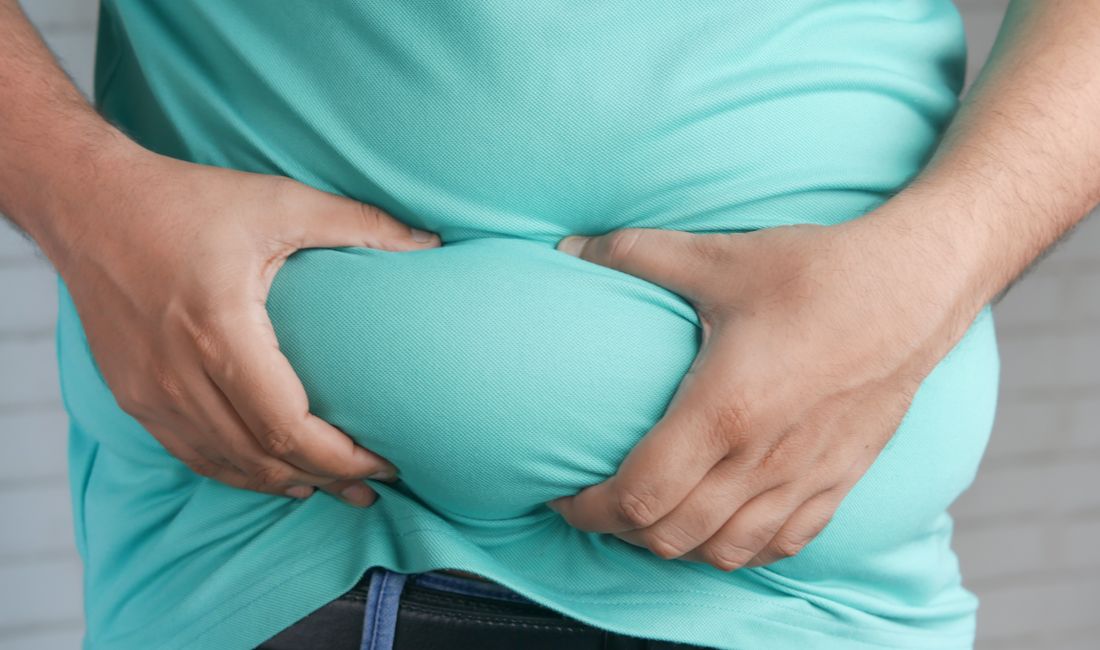 Mãos segurando a gordura abdominal, que é macia e pode ser pinçada