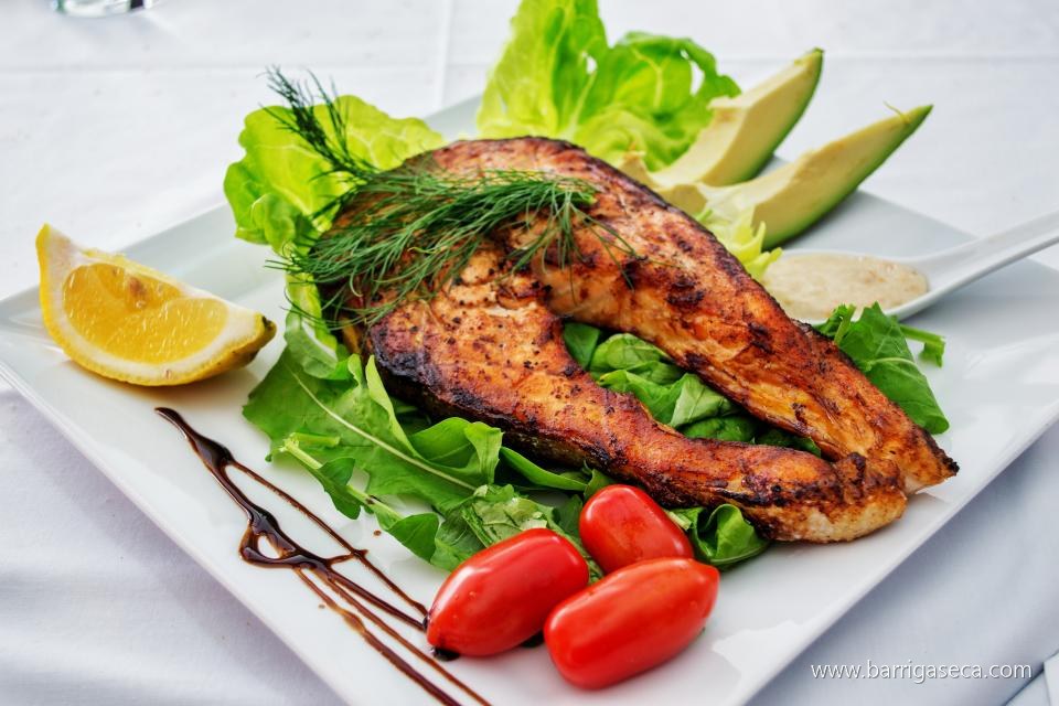 Prato com peixe grelhado, salada e limão