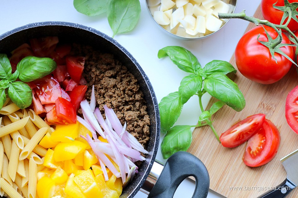 Panela com carne moída, tomate e legumes sendo preparados